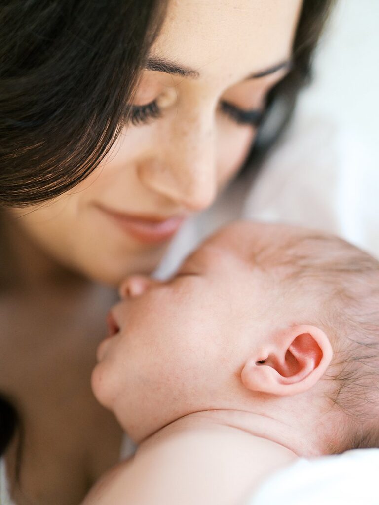 A Close-Up View Of A Baby Sleeping Peacefully On His Mother's Chest.