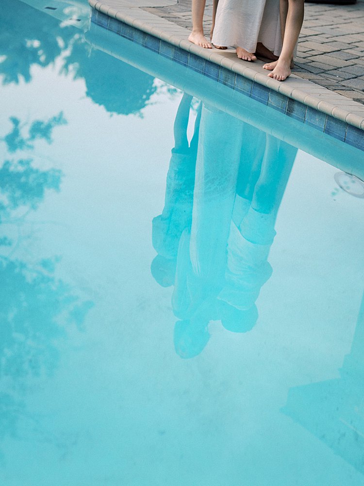 Reflection Of A Mother And Her Two Sons In A Pool.