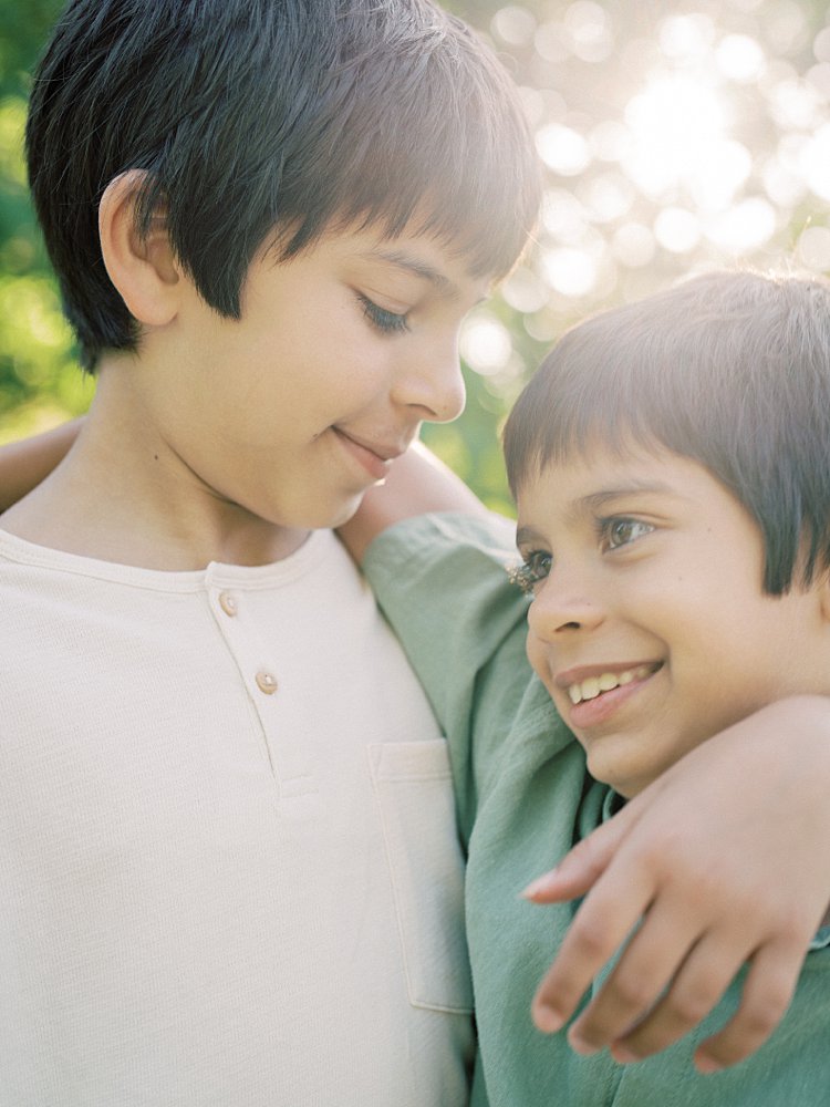 Two Young Boys Smile As They Each Have An Arm Around One Another.