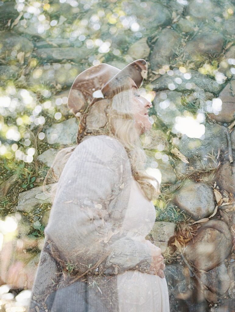 A Double Exposure Of Cobblestones And A Pregnant Mom In A Hat Looking Up To The Sky With Eyes Closed. 