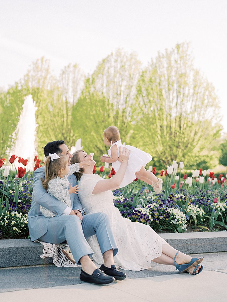 Family Of Four Sits In Front Of The Red And White Tulips At The Mormon Temple Washington Dc.
