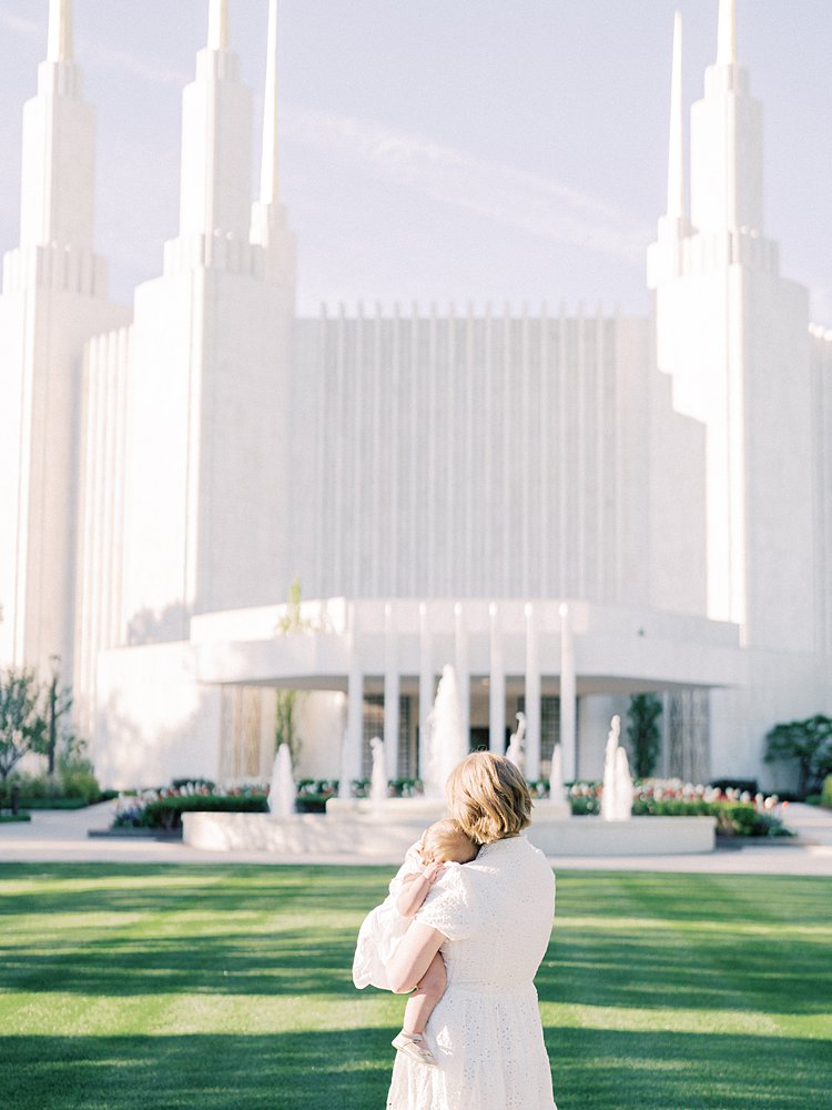 A Mother Holds Her Daughter Close To Her And Admires The Mormon Temple In Washington Dc.