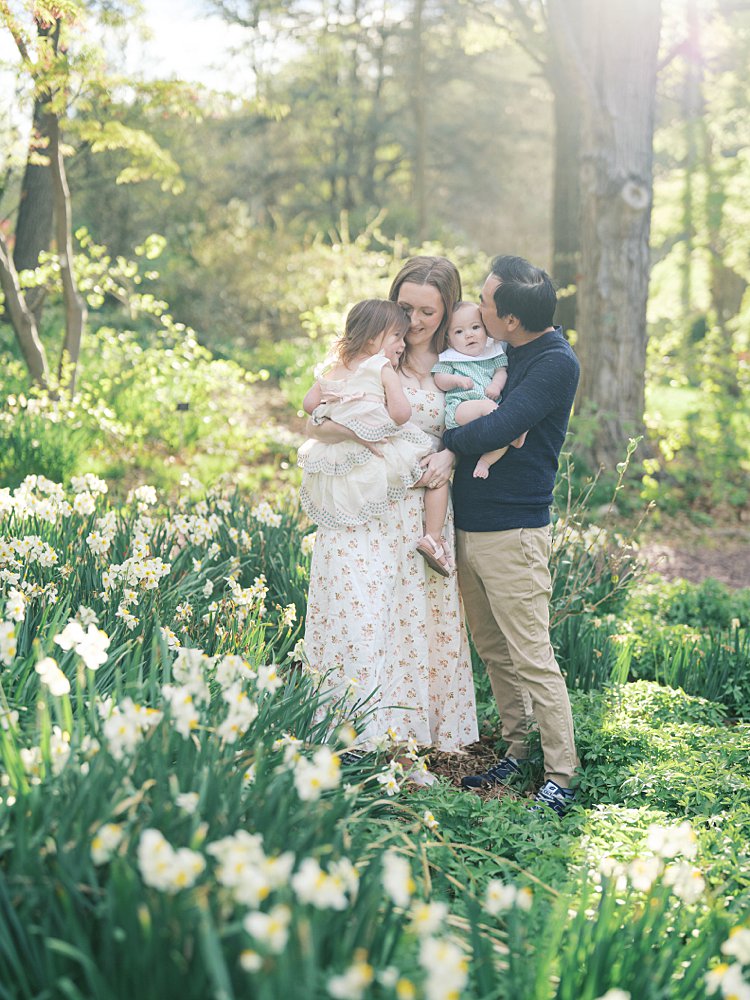 A Family Of Four Stand In Daffodils At Brookside Gardens Outside Of Washington, D.c.