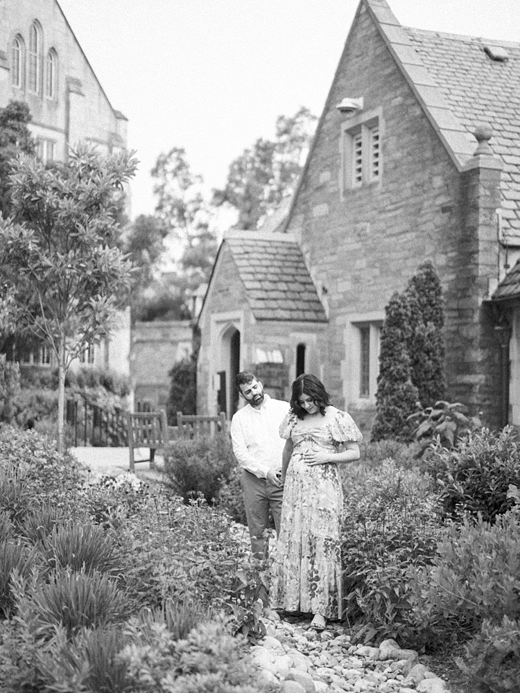 A Black And White Image Of A Couple Walking Along The Grounds Of The National Cathedral.