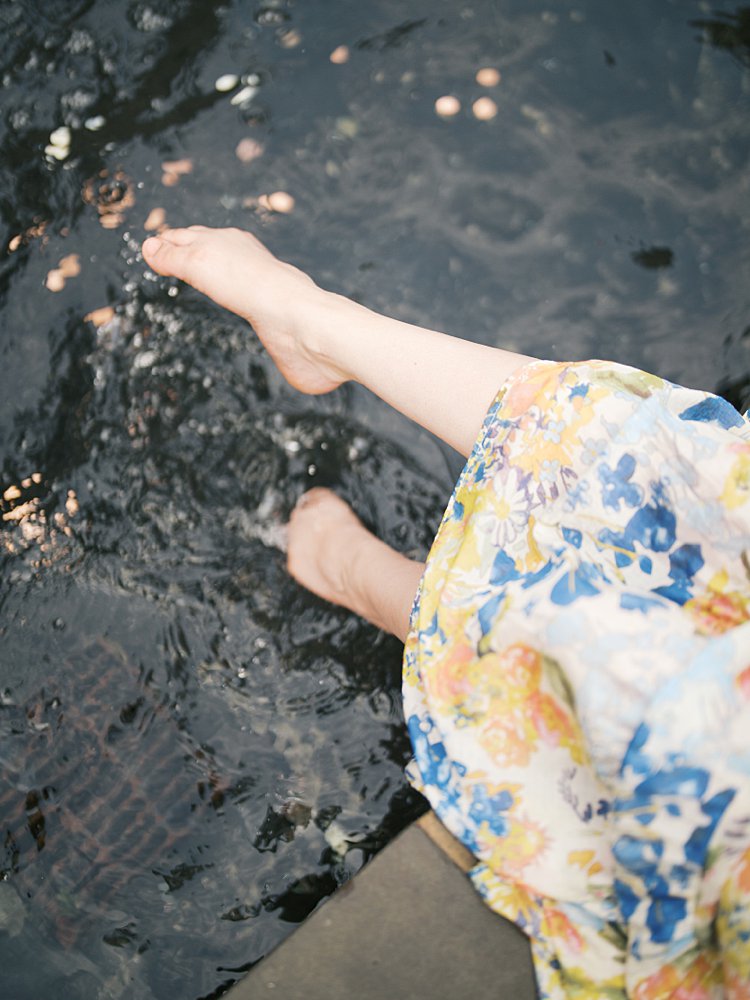 A Woman Splashes Her Feet In A Fountain.