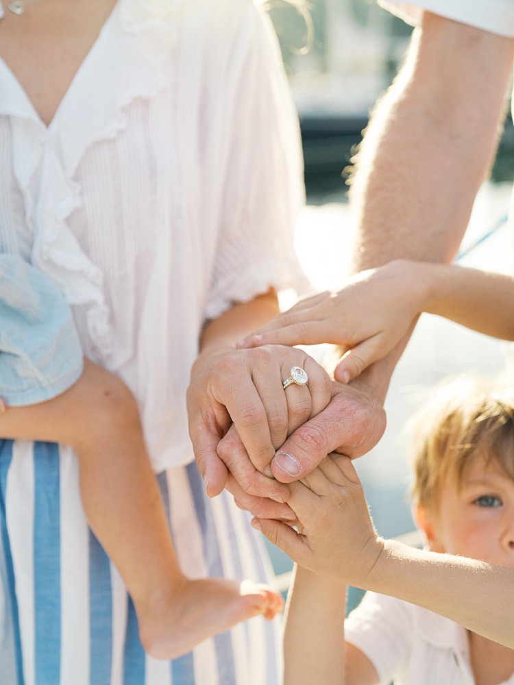 Kids and father place their hands on a mother's hand.