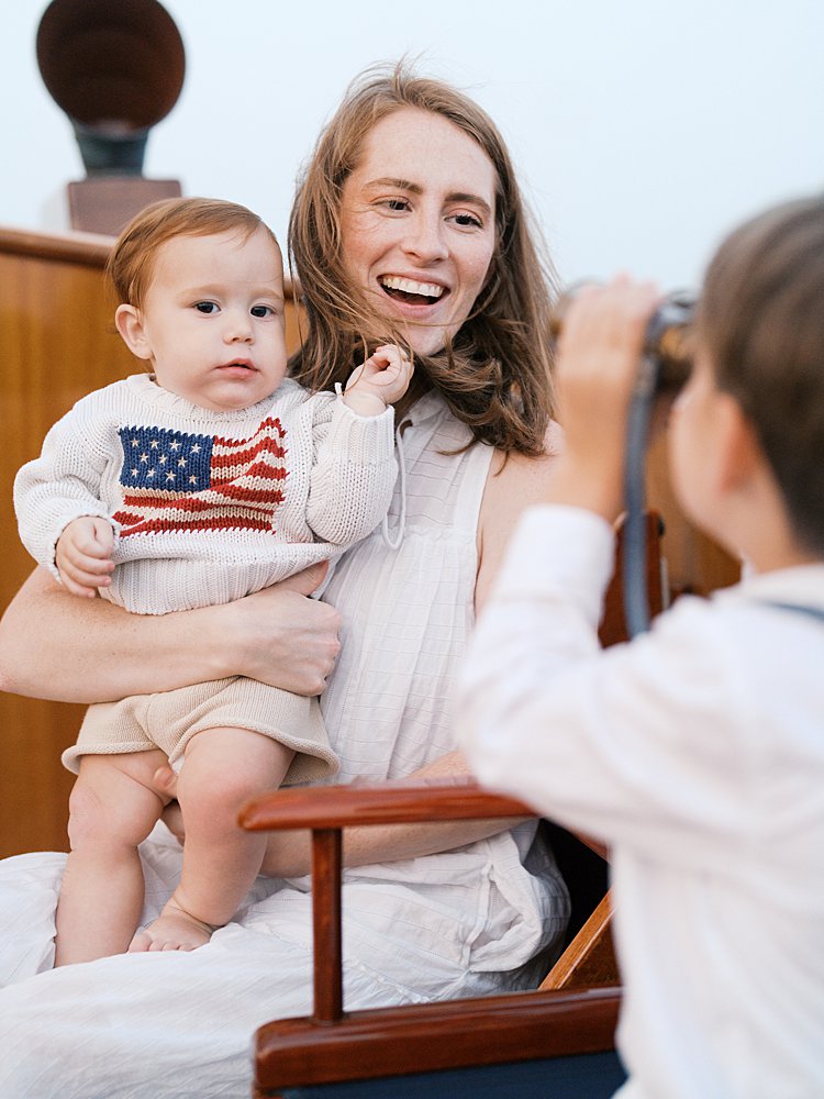 Mother smiles at her son who is looking at her through binoculars.