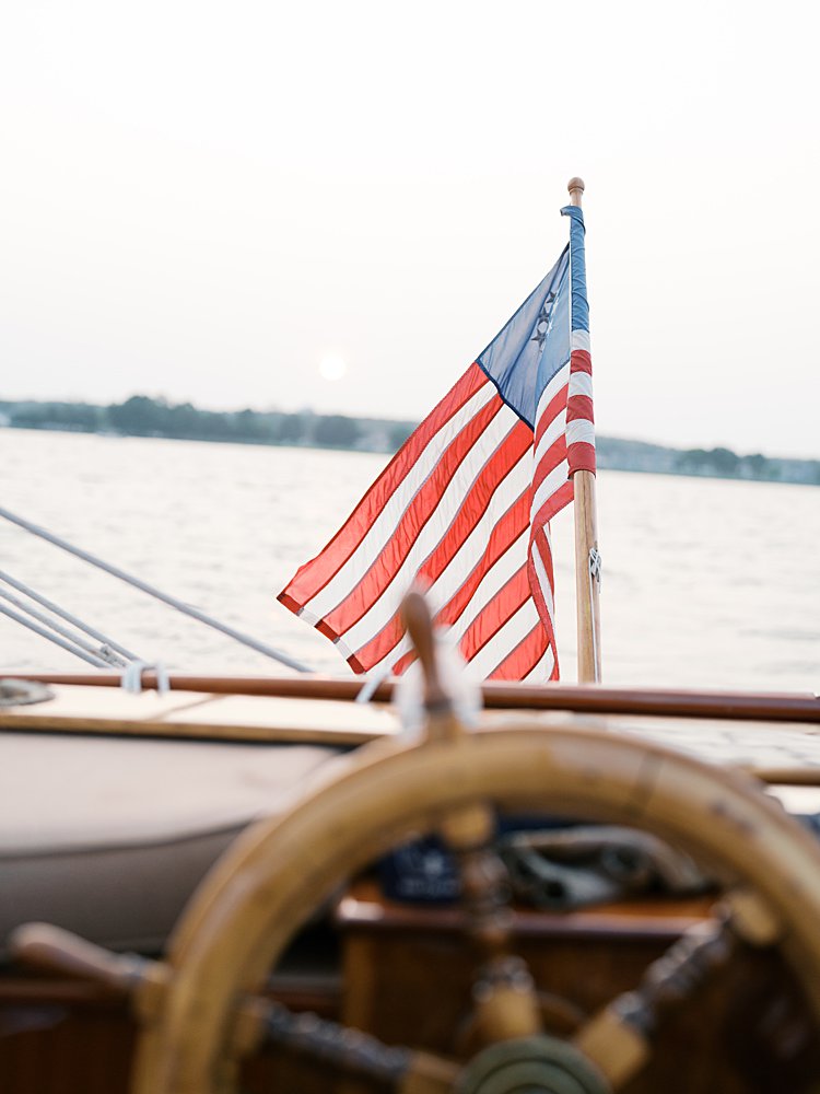 View of an American flag from the steering wheel of a sailboat.