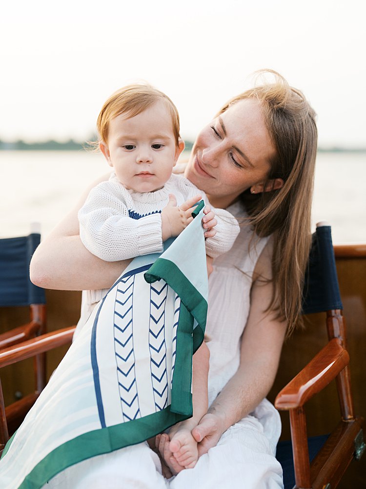 Mother holds her young son during their sailboat family photos.