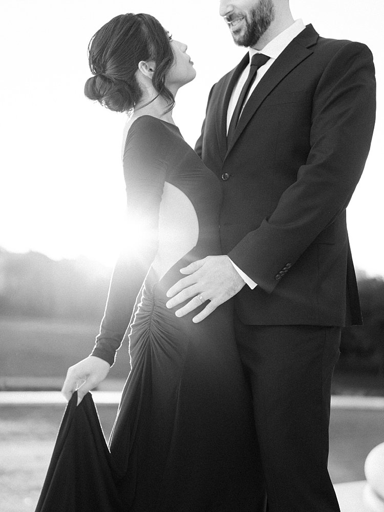 A Black And White Image Of A Woman And Man In Formal Attire Standing In Golden Light At The Jefferson Memorial.