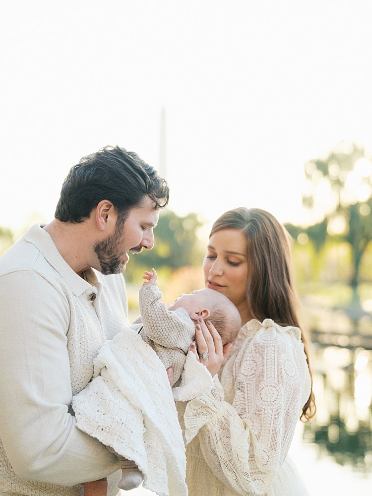 Mother And Father Soothe Their Newborn Baby During Their Constitution Garden Newborn Photos.