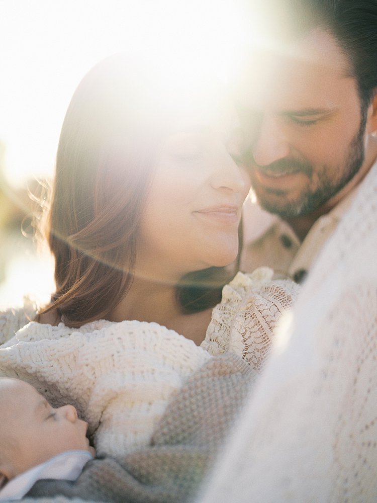 Glowing Photo Of Woman And Man Leaning Into One Another During Their Constitution Garden Newborn Photos.