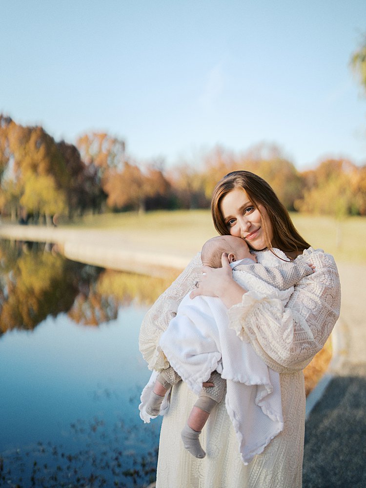 Mother Looks At The Camera During Their Constitution Garden Newborn Photos.