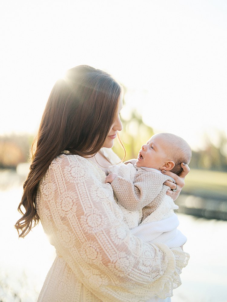 Mother Looks Down At Her Baby Boy During Their Constitution Garden Newborn Photos.