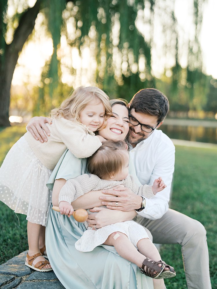 A Family Goes In For A Big Hug Seated On A Stone Pathway At Constitution Gardens.