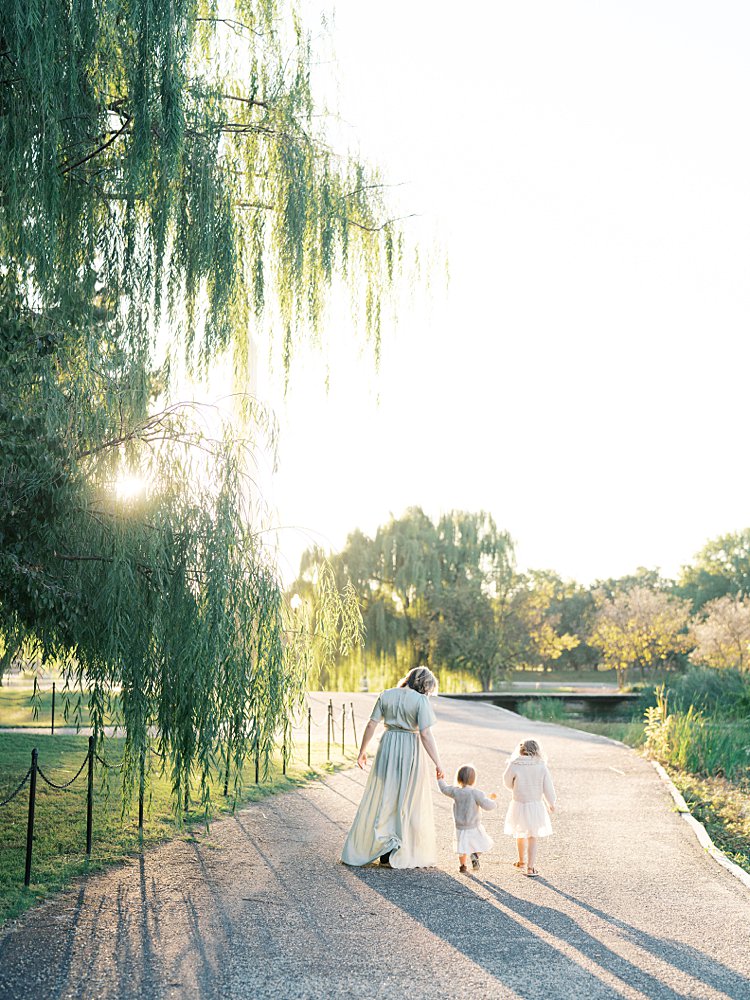 A Mother Walks With Her Two Young Girls During Their Downtown Dc Family Photos At Constitution Gardens.