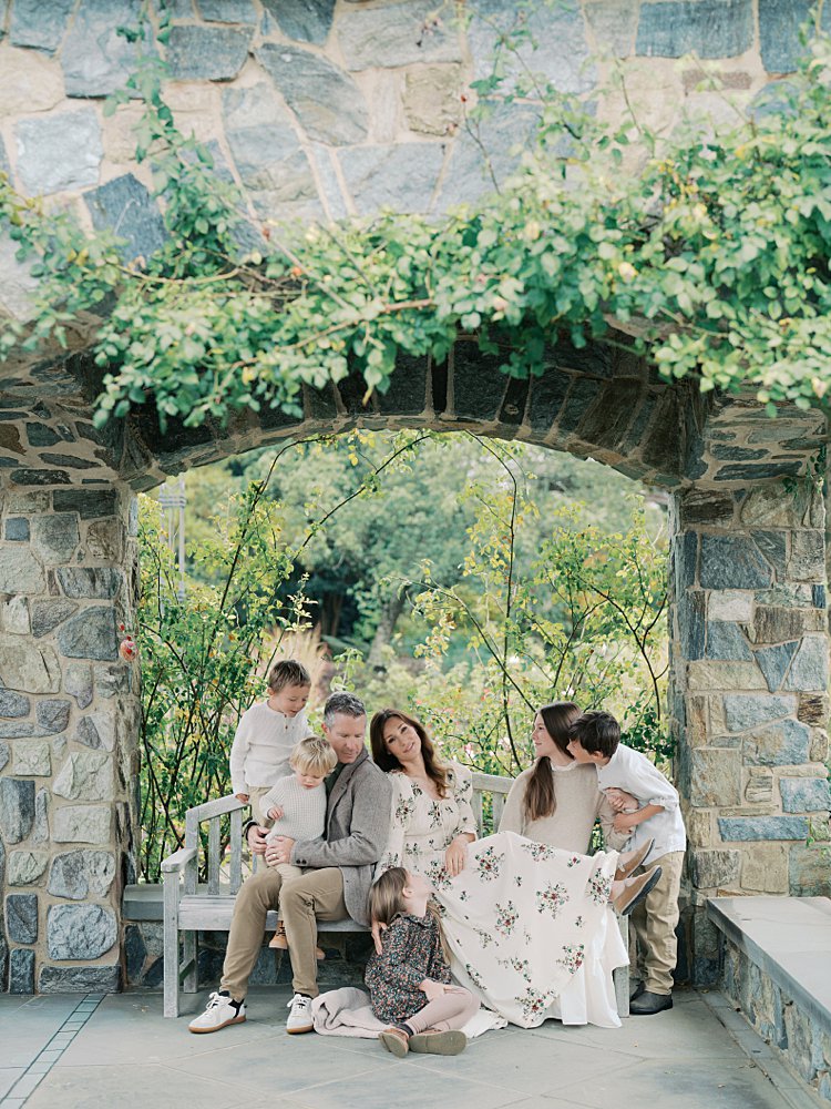 A Mother Looks At The Camera As Her Husband And Five Children Sit With Her During Their Lewis Ginter Botanical Garden Photos