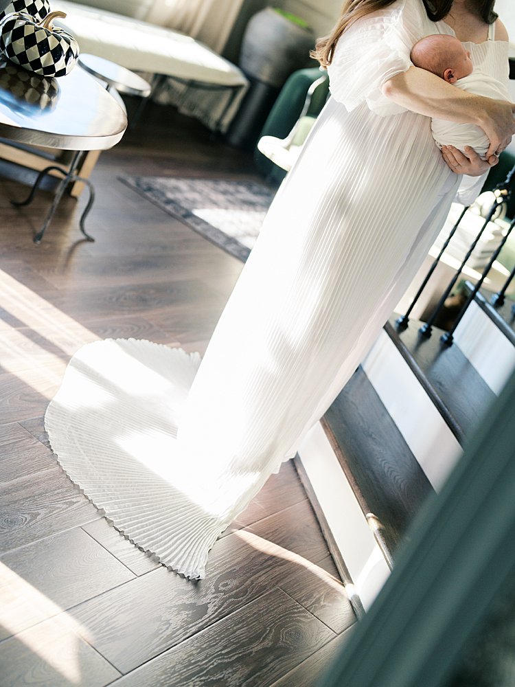 Dutch Angle View Of Mother In White Dress Holding Newborn Baby.