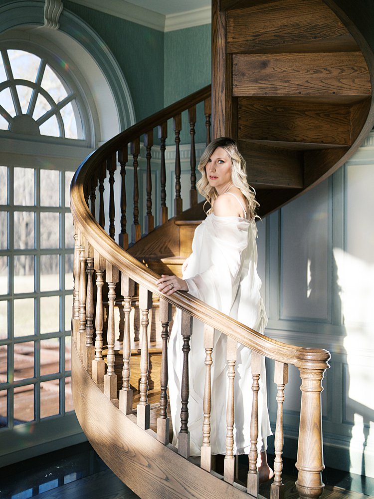 Blonde Pregnant Woman Stands In Direct Light, Going Up Steps During Her Maternity Photos At The Estate At River Run.