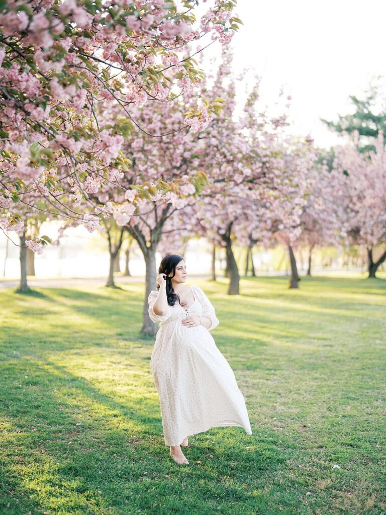 Expectant Mother Walking Through Rows Of Kwanzan Cherry Blossom Trees At East Potomac Park, Her Dress Flowing In The Warm Evening Light.