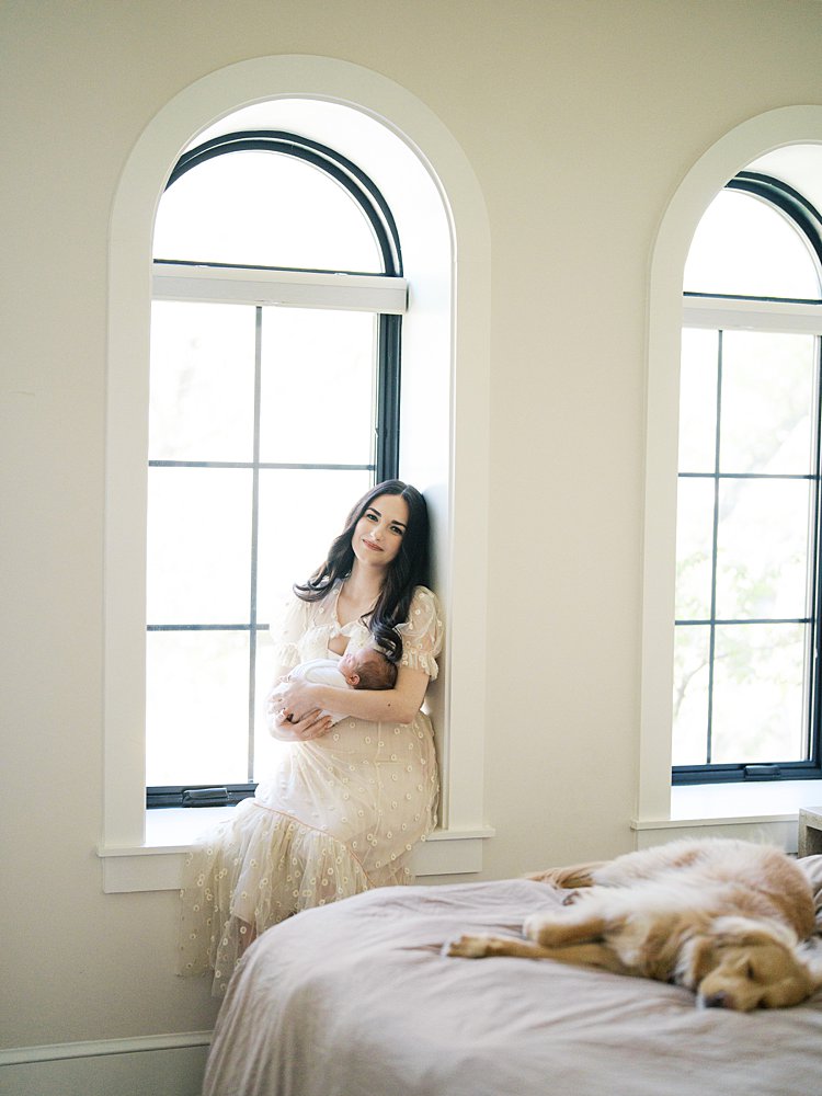 A Couple Stands On A Charming Brick Sidewalk Beneath Blooming Pink Cherry Blossom Trees, Looking Down At Their Newborn Together — A Dreamy Outdoor Portrait That Shows Exactly What Happens After Your Session And Why These Images Are Worth Every Moment.