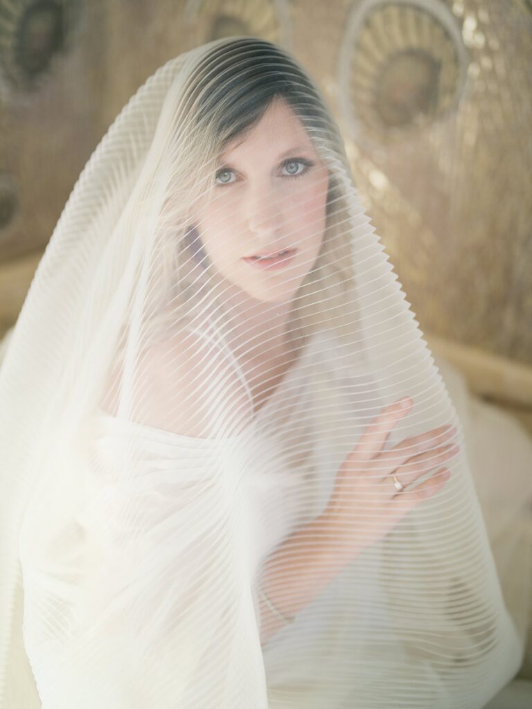 A Close, Dreamy Portrait Of A Mother Wrapped In Sheer Fabric With Soft, Diffused Light Creating A Delicate And Intimate Feel.