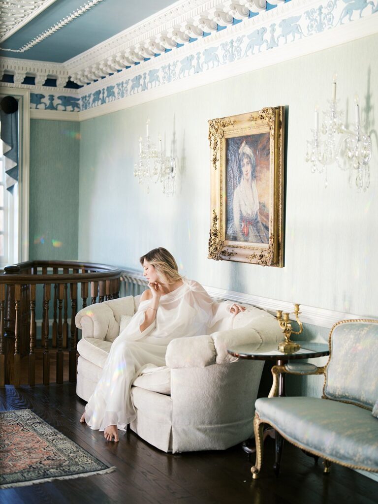 A Mother Rests On A Sofa In An Elegant Historic Interior With Ornate Details And Soft Natural Light, A Timeless Setting That Shows When Is The Best Time To Get Family Photos In The Dmv Can Also Include Beautiful Indoor Spaces.