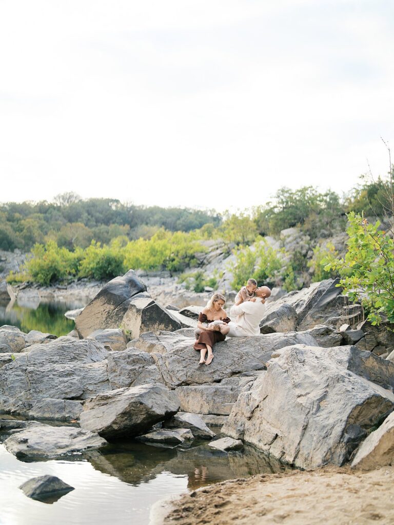 Family Gathers On The Boulders Beside The Calm Potomac At Great Falls, A Natural Favorite Among Washington Dc Fall Foliage Locations.