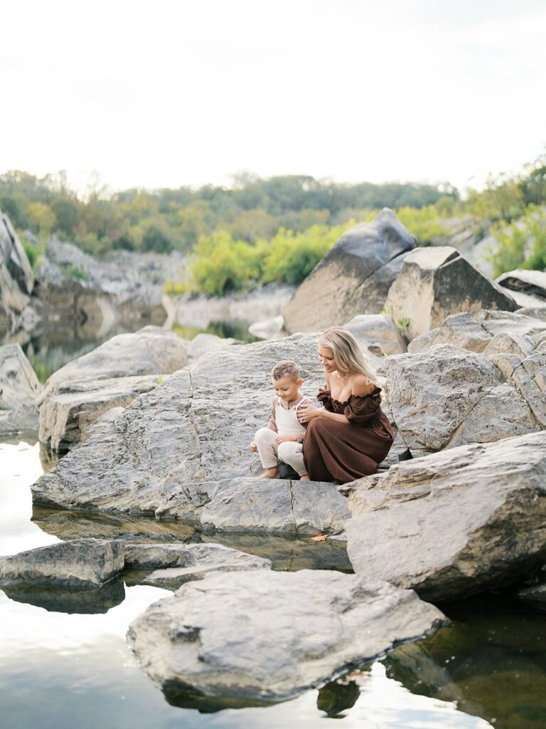 Mother Holds Her Son On The Riverside Rocks At Great Falls On The Maryland Side, One Of The Best Washington Dc Fall Foliage Locations.