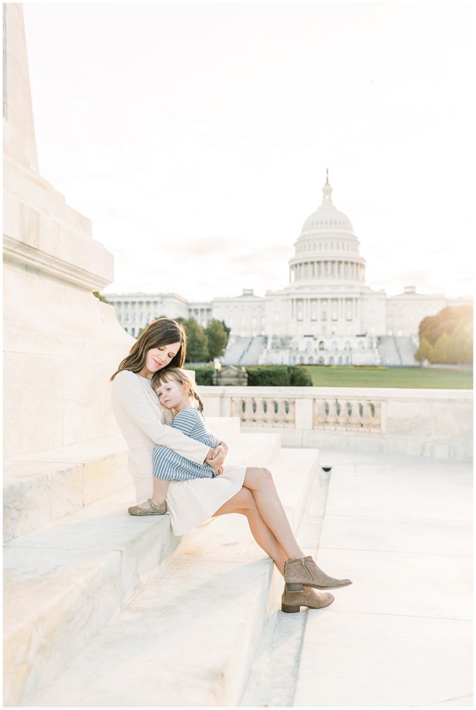 Mother holding daughter in front of the United States Capitol during a DC Family Photography session