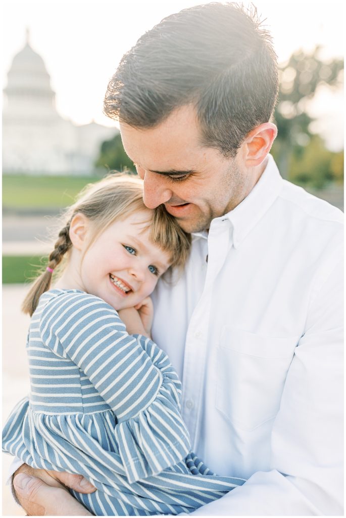A father holding his daughter his young daughter in DC during a family photography session.