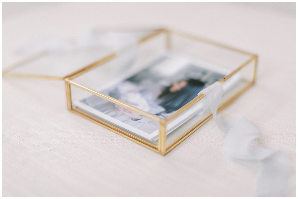 Photographs in a gold, glass box with light blue ribbon for DC Fine Art Photographer Marie Elizabeth Photography