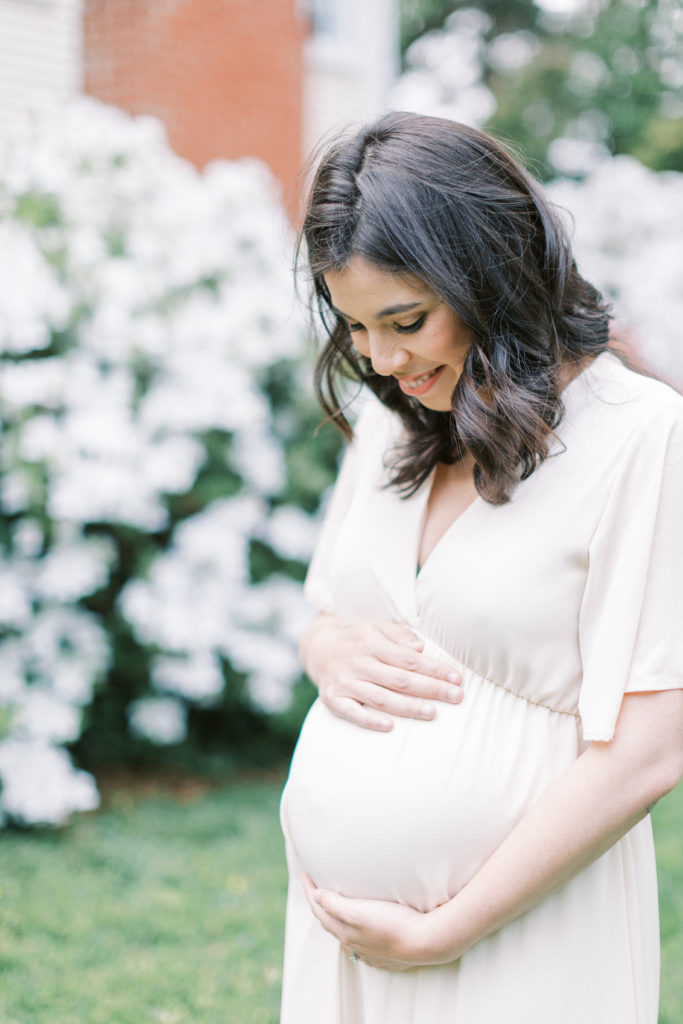 A mother smiling down at her belly during Northern Virginia maternity session.
