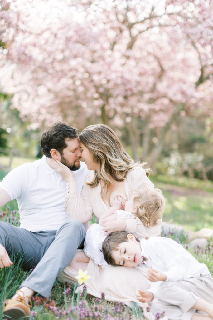 A mother nurses her toddler daughter with her son and husband sitting nearby in this Maryland family session.
