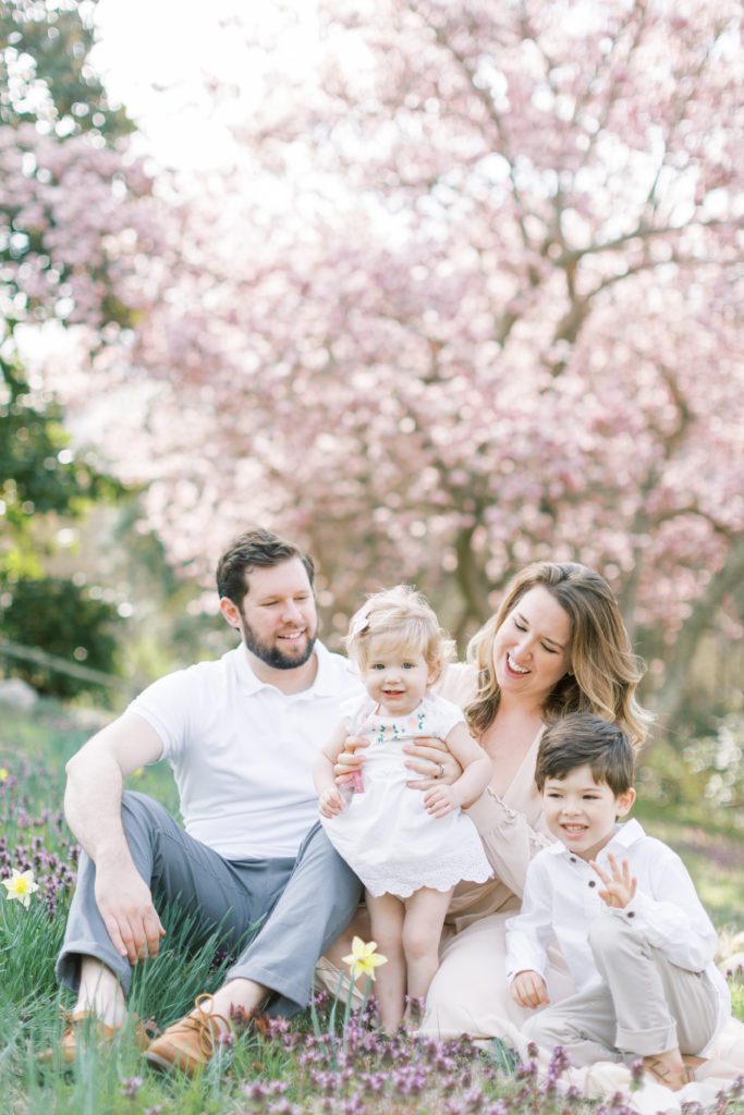A family sits in a field of flowers during a Maryland family photo session.