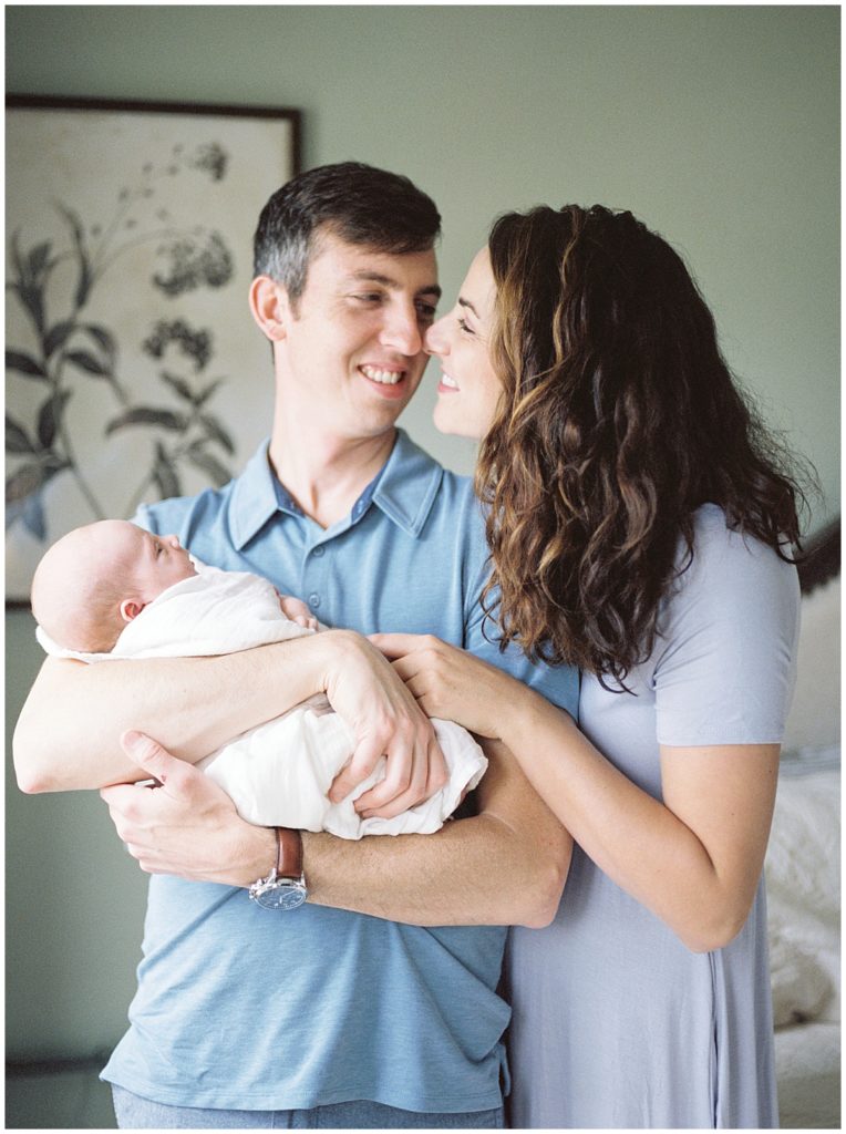 Mother and father nuzzle together during Bethesda newborn photography shoot.