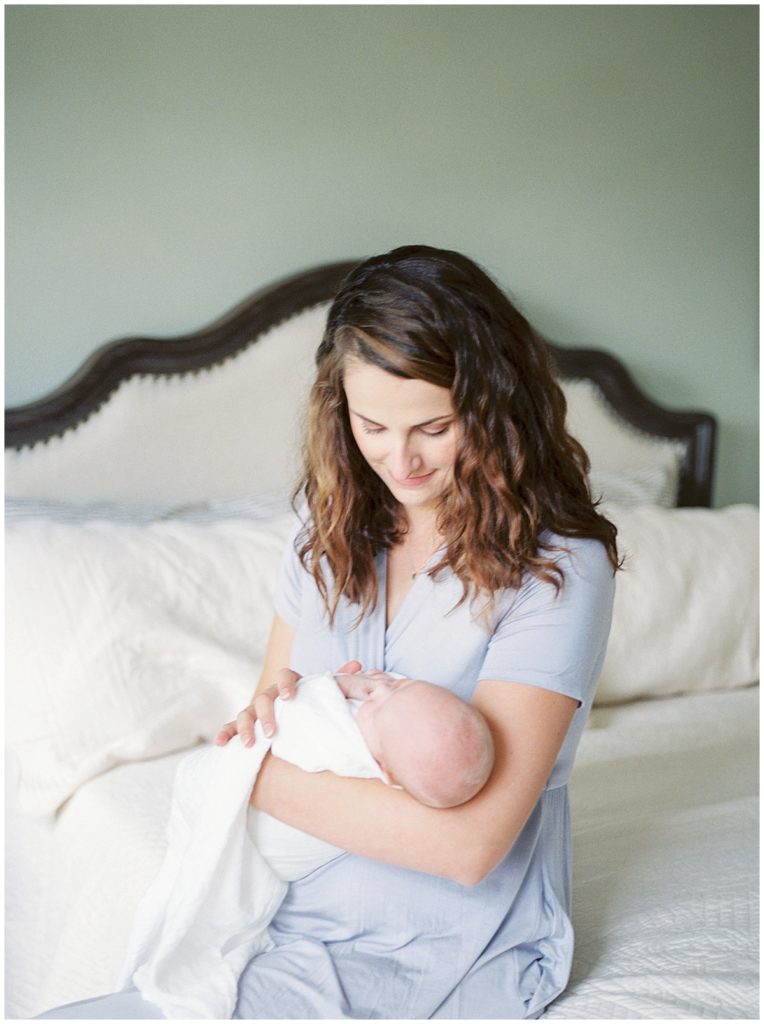 Mother looks down at her daughter during a Maryland newborn session.