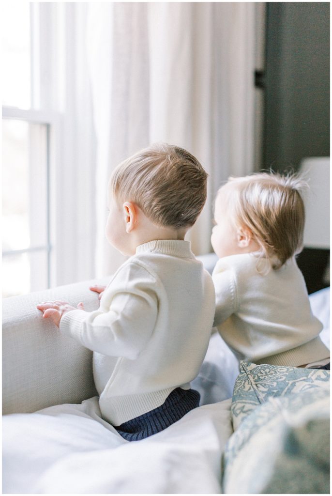 Twins looking out a window