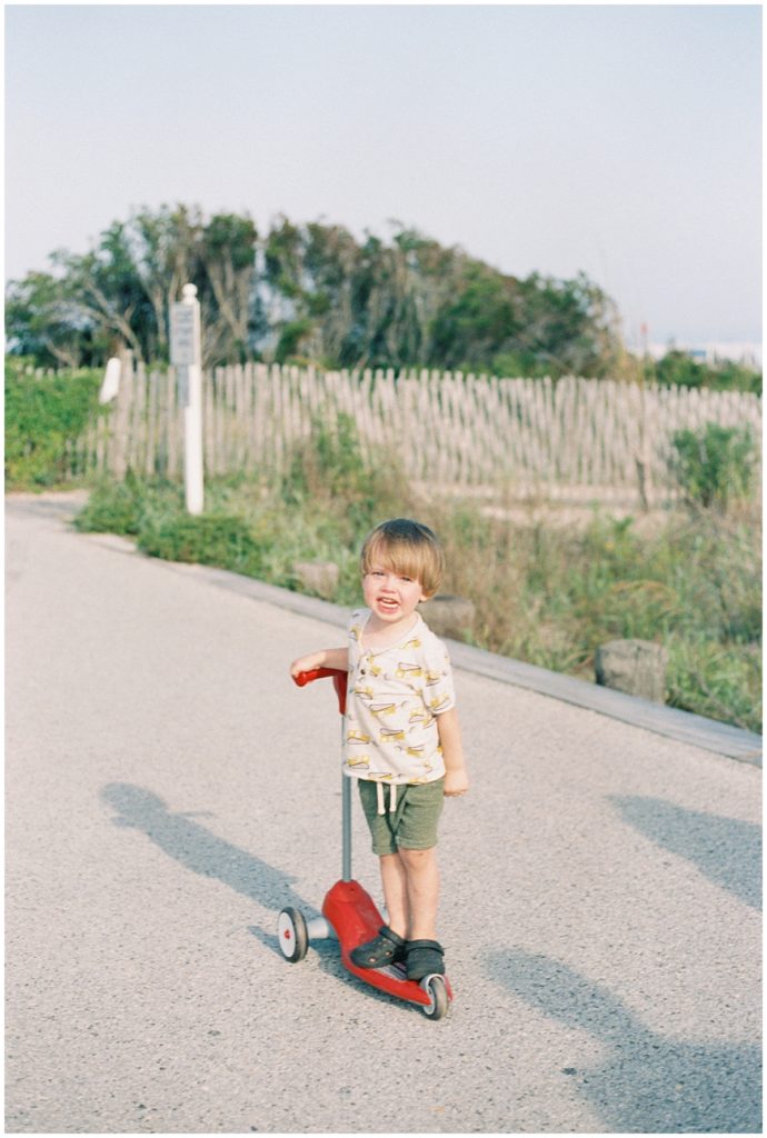 Little boy on a scooter on boardwalk