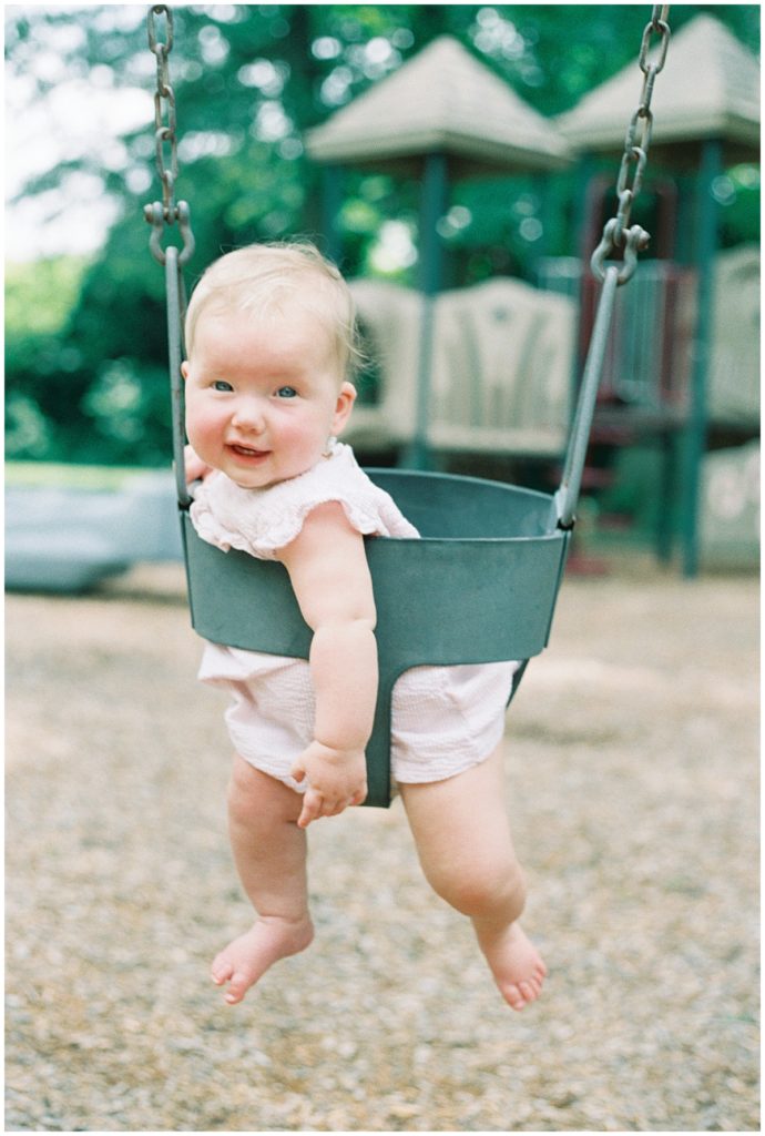 Baby girl in a swing on a playground