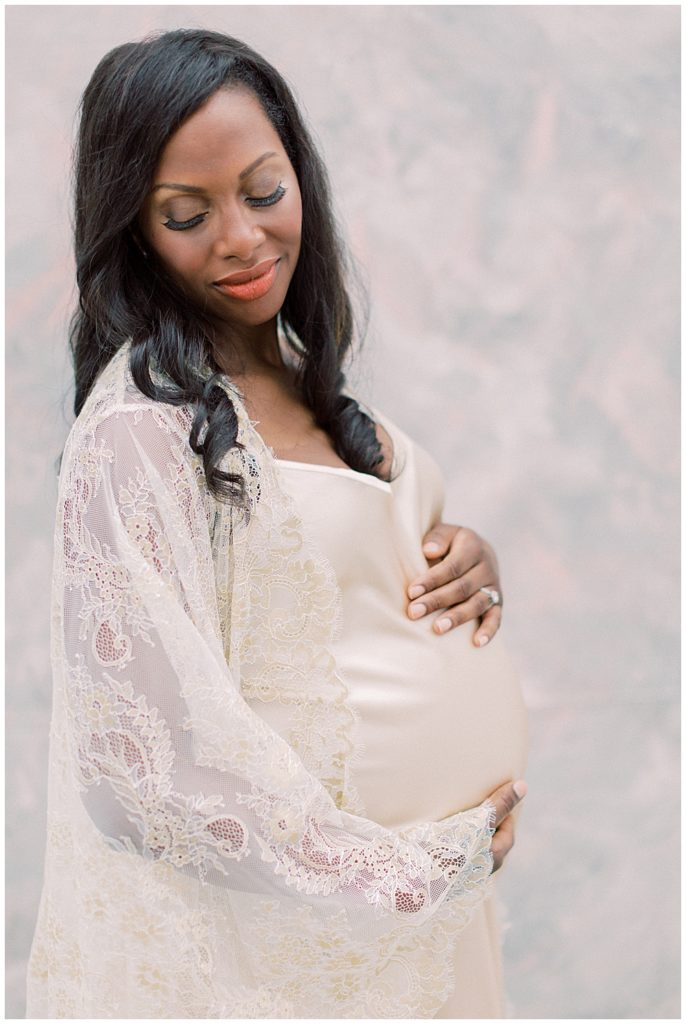Mother looks over her shoulder during maternity session in DC studio