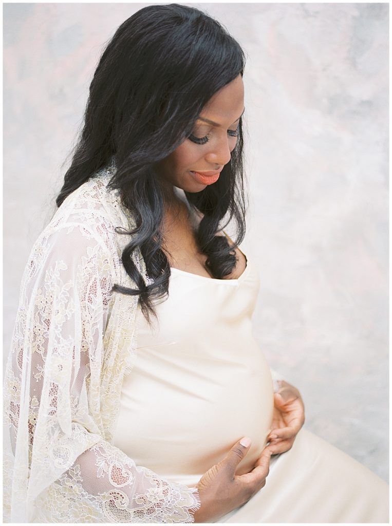 Mother sits on a stool during her DC studio maternity session