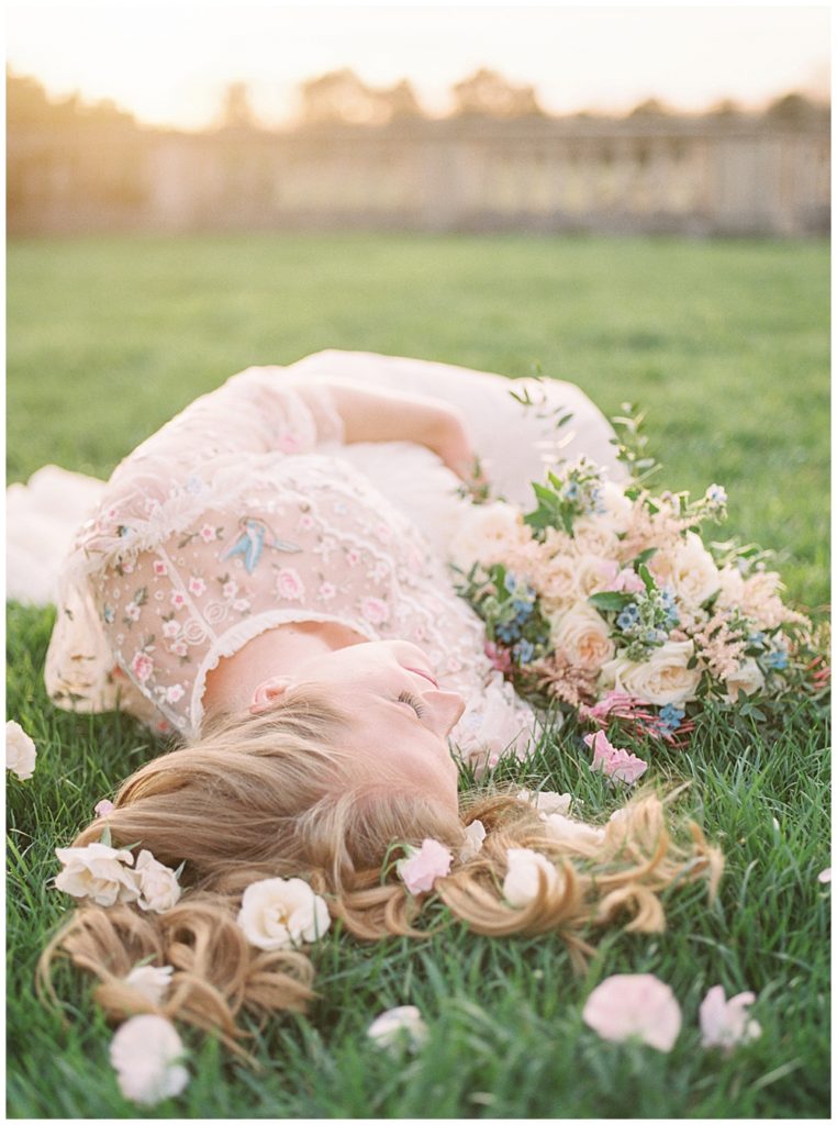 Washington, D.C. Maternity Photographer | Pregnant woman lays on ground with flowers at The Great Marsh Estate in Northern Virginia
