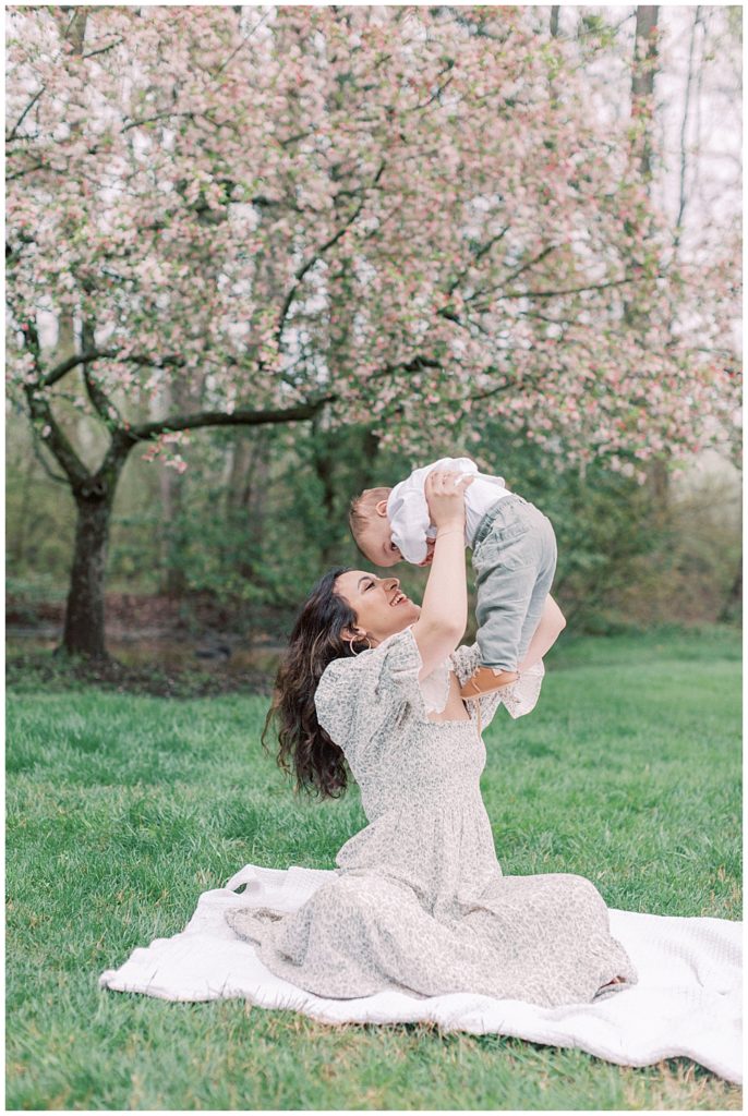 Mother holds her son in the air during a family photo session in Maryland.