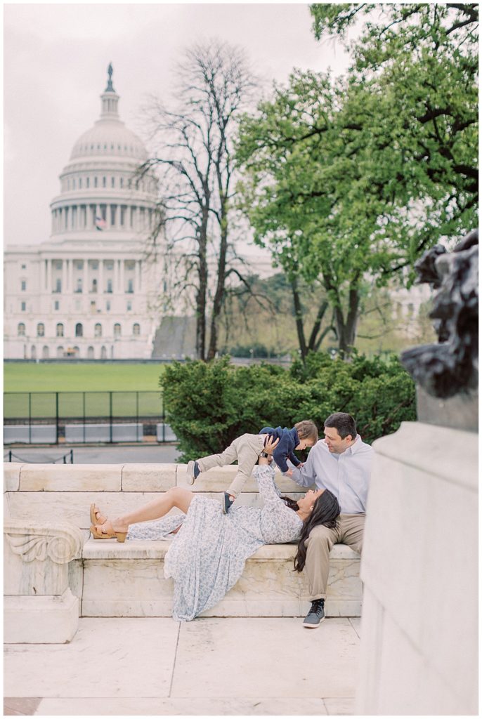 Mother holds son up in front of Capitol Building during photo session