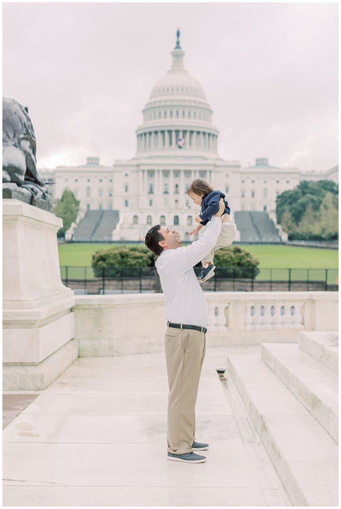 Father holds his son up in the air during a family session at the US Capitol Building
