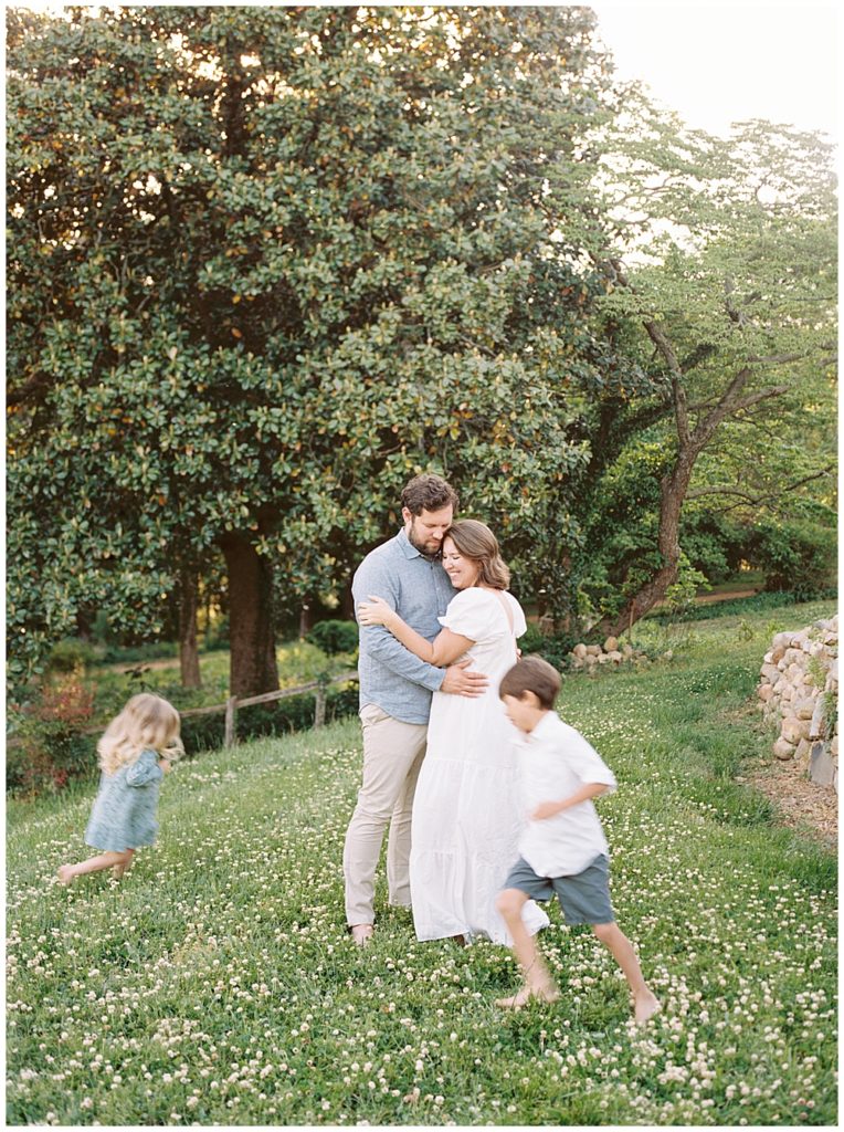 Little kids run around their mother and father during their Maryland photo session