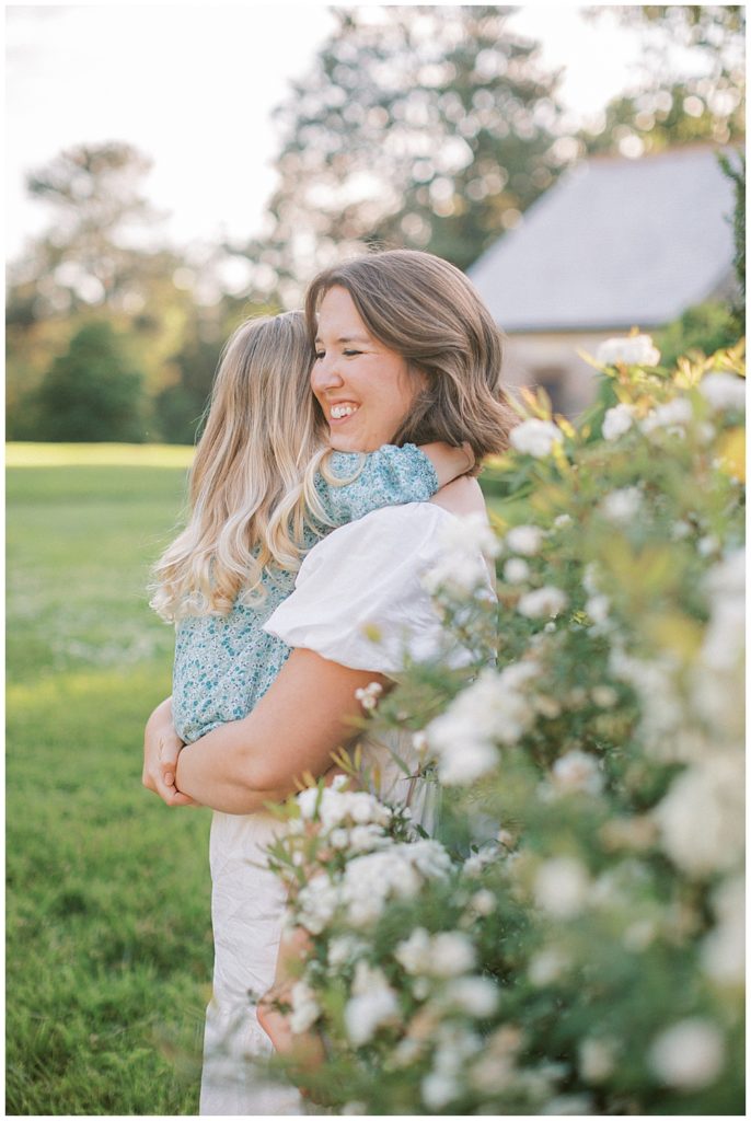 Mother smiles and holds her young daughter | Maryland Family Photographers