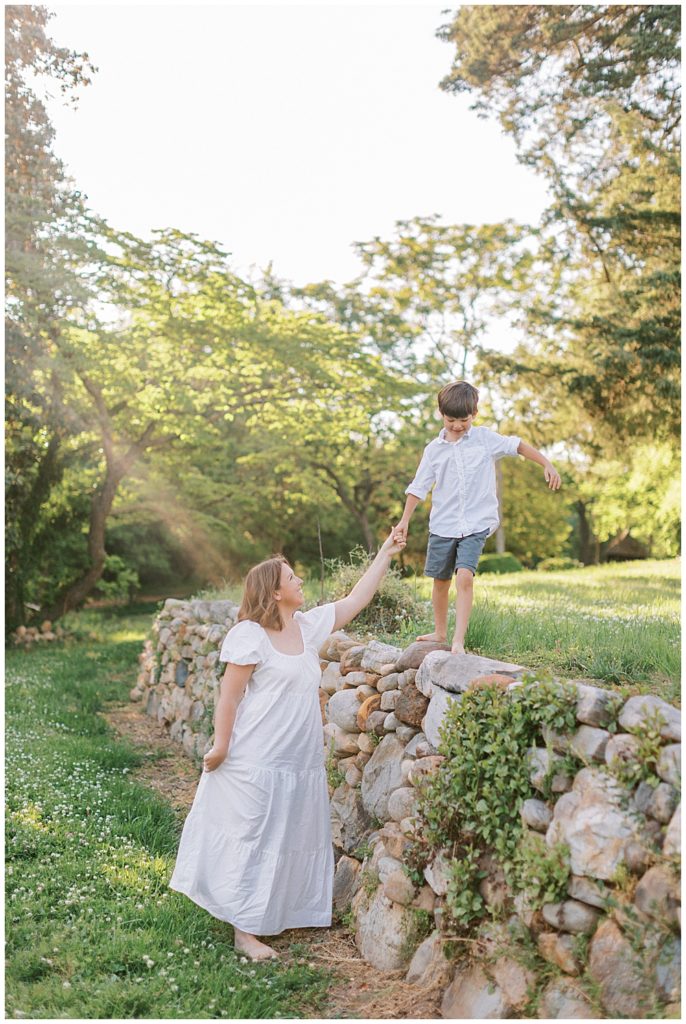 Mother walks with her son along a stone fence