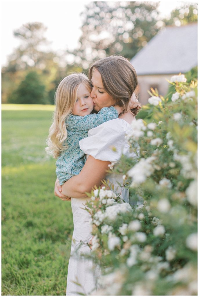 Mother kisses her daughter's cheek at Mulberry Fields